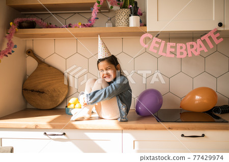 Girl laughing out loud while having great mood during her birthday party at home 77429974