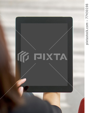 Businesswoman in black suit use her finger press on the screen to waking tablet computer from sleep mode. Businesswoman in black suit use her finger press on the screen to waking tablet computer from sleep mode. 77430198