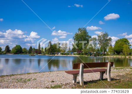 Bench overlooking lake at bavarian camping Bench overlooking lake at bavarian camping 77431629
