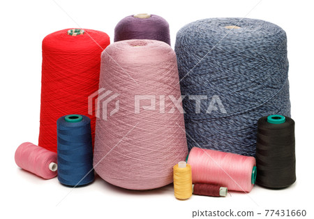 Cones and spools of color threads on white background Cones and spools of color threads on white background 77431660