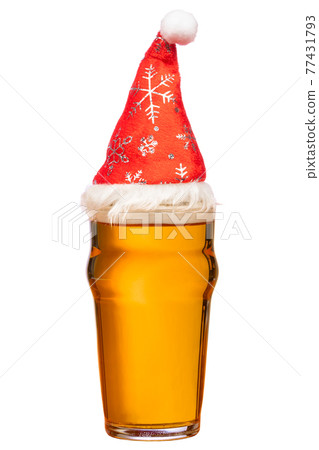 Pint glass of ale or beer with christmas red hat on isolated 77431793