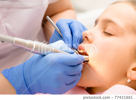 Preteen girl receiving dental filling procedure in pediatric dental clinic Preteen girl receiving dental filling procedure in pediatric dental clinic 77431881