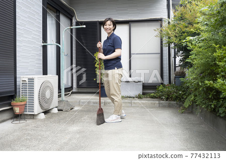 House cleaning woman sweeping the parking lot 77432113