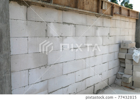 SEREMBAN, MALAYSIA -MARCH 19, 2021: Autoclaved aerated concrete block or known as AAC block used at the construction site. Install by workers using special mortar. Easy and fast.   77432815