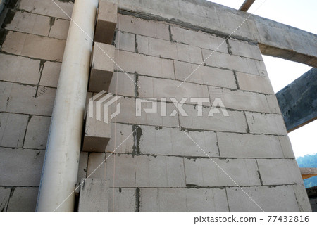 SEREMBAN, MALAYSIA -MARCH 19, 2021: Autoclaved aerated concrete block or known as AAC block used at the construction site. Install by workers using special mortar. Easy and fast.   77432816