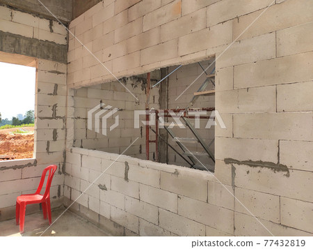 SEREMBAN, MALAYSIA -MARCH 19, 2021: Autoclaved aerated concrete block or known as AAC block used at the construction site. Install by workers using special mortar. Easy and fast.   77432819