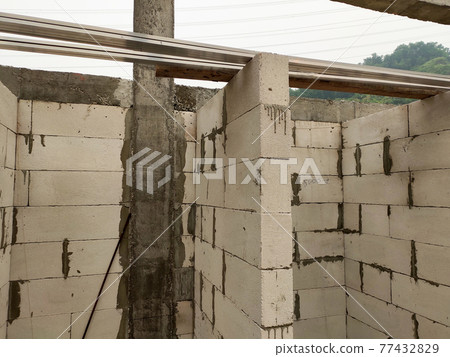 SEREMBAN, MALAYSIA -MARCH 19, 2021: Autoclaved aerated concrete block or known as AAC block used at the construction site. Install by workers using special mortar. Easy and fast. SEREMBAN, MALAYSIA -MARCH 19, 2021: Autoclaved aerated concrete block or known as AAC block used at the construction site. Install by workers using special mortar. Easy and fast. 77432829