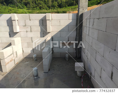SEREMBAN, MALAYSIA -MARCH 19, 2021: Autoclaved aerated concrete block or known as AAC block used at the construction site. Install by workers using special mortar. Easy and fast. SEREMBAN, MALAYSIA -MARCH 19, 2021: Autoclaved aerated concrete block or known as AAC block used at the construction site. Install by workers using special mortar. Easy and fast. 77432837