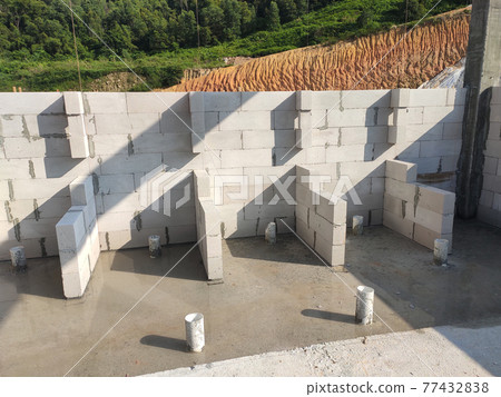 SEREMBAN, MALAYSIA -MARCH 19, 2021: Autoclaved aerated concrete block or known as AAC block used at the construction site. Install by workers using special mortar. Easy and fast. SEREMBAN, MALAYSIA -MARCH 19, 2021: Autoclaved aerated concrete block or known as AAC block used at the construction site. Install by workers using special mortar. Easy and fast. 77432838
