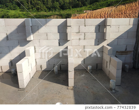 SEREMBAN, MALAYSIA -MARCH 19, 2021: Autoclaved aerated concrete block or known as AAC block used at the construction site. Install by workers using special mortar. Easy and fast. SEREMBAN, MALAYSIA -MARCH 19, 2021: Autoclaved aerated concrete block or known as AAC block used at the construction site. Install by workers using special mortar. Easy and fast. 77432839
