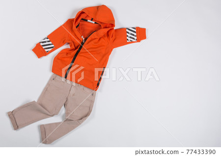 children's clothing, beige pants and orange jacket are laid out like a rapidly flying superhero, the concept of children's clothing, copy space children's clothing, beige pants and orange jacket are laid out like a rapidly flying superhero, the concept of children's clothing, copy space 77433390