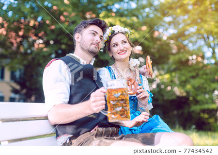 Woman and man in Bavarian tracht enjoying the country 77434542