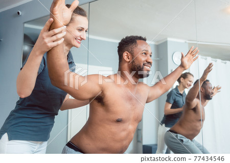 Young man receiving physical therapy after sport injury 77434546