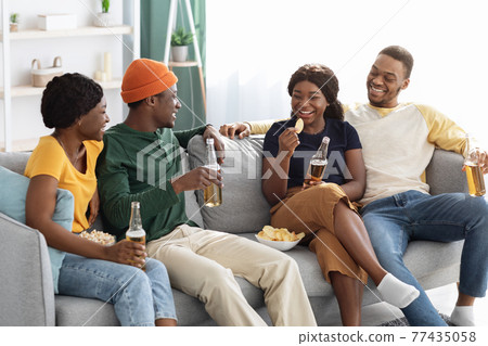 Positive african american friends having home party, drinking beer 77435058