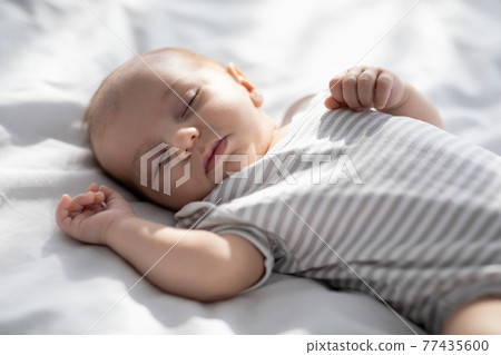 Closeup Shot Of Cute Lovely Newborn Baby Sleeping On Bed Closeup Shot Of Cute Lovely Newborn Baby Sleeping On Bed 77435600
