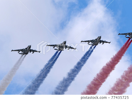 MOSCOW, RUSSIA - MAY 7, 2021: Avia parade in Moscow. Group of Russian fighters Sukhoi Su-25 with painted russian flag in the sky on parade of Victory in World War II in Moscow, Russia 77435725