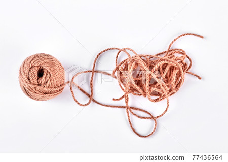 Ball of brown yarn on white background. Ball of brown yarn on white background. 77436564