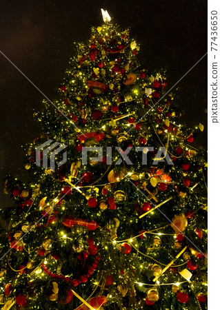 Christmas big tree decorated with a burning garland festive decor 77436650