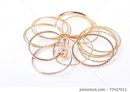 Golden bracelets and jewelry, white background. 77437011