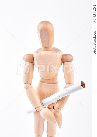 Wooden dummy with white cigarette. Wooden dummy with white cigarette. 77437251