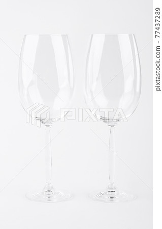 Two empty wine glasses over white. 77437289