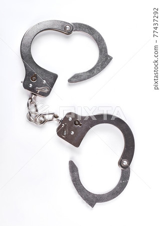 Silver handcuffs on white background. Silver handcuffs on white background. 77437292