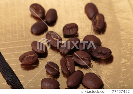 Roasted coffee beans on a golden surface. Roasted coffee beans on a golden surface. 77437432