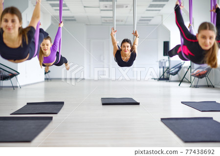 Anti-gravity yoga, group training with hammocks 77438692