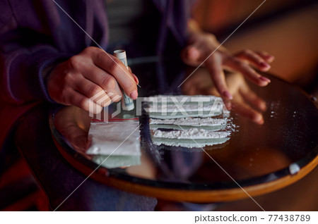 Drug addict woman with powder prepares a dose Drug addict woman with powder prepares a dose 77438789