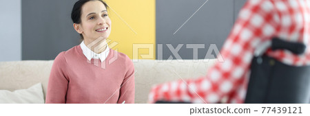 Psychologist working with patient in wheelchair in rehabilitation center 77439121