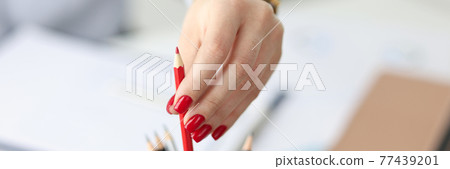 Female hand with red manicure pulling out pencil in office closeup Female hand with red manicure pulling out pencil in office closeup 77439201