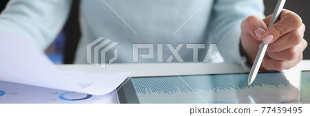 Woman holding documents in hands and working with tablet closeup 77439495