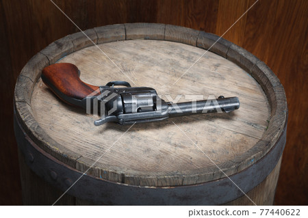 Old west revolver 45 cal on wooden barrel Old west revolver 45 cal on wooden barrel 77440622