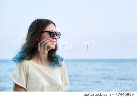 Beautiful teenager girl in sunglasses on sea beach, nature sea sky background for copy space 77440999