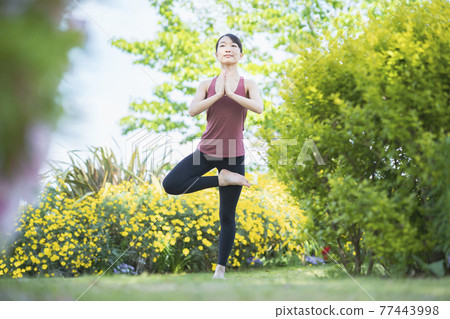 在綠色公園做瑜伽的年輕女子 在綠色公園做瑜伽的年輕女子 77443998