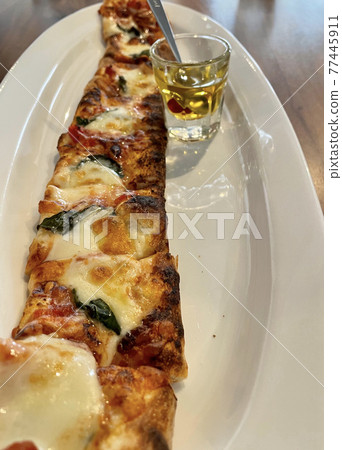 Long pizza with teriyaki chicken and hot oil Long pizza with teriyaki chicken and hot oil 77445911