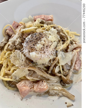 蔬菜豐富的舞茸培根蛋麵，上面放著一顆煮熟的雞蛋 77446280