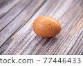 Close-up view of raw chicken eggs on wooden background. Eggs are often said to be the original superfood because of their many health benefits. 77446433