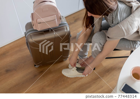Modern suitcase full of things, handbag and straw hat. Baggage case packing getting ready to travel 77448314