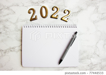 notebook with a blank sheet, a pen for writing plans for 2022 77448533