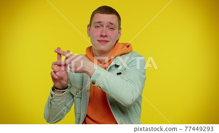 Cheerful teen man showing hashtag symbol with hands, likes tagged message, popular viral content Cheerful teen man showing hashtag symbol with hands, likes tagged message, popular viral content 77449293