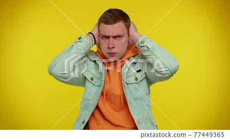 Frustrated irritated man covering ears, avoiding advice ignoring unpleasant noise loud voices Frustrated irritated man covering ears, avoiding advice ignoring unpleasant noise loud voices 77449365