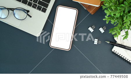 Mock up mobile phone with empty screen and laptop on office desk. Mock up mobile phone with empty screen and laptop on office desk. 77449508