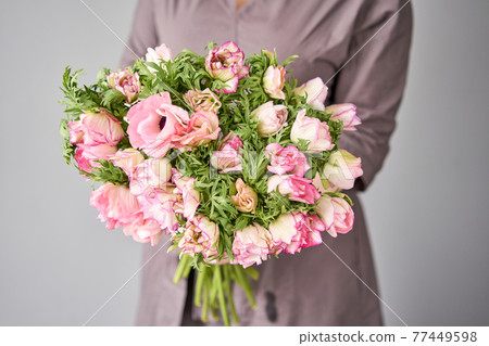 Beautiful bouquet of pink anemones in woman hand. the work of the florist at a flower shop. A small family business Beautiful bouquet of pink anemones in woman hand. the work of the florist at a flower shop. A small family business 77449598