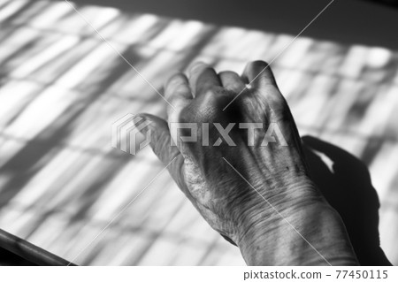 Close-up of blind shadow and grandma's hand black-and-white photo 77450115