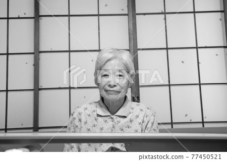 一位白髮蒼蒼的奶奶坐在窗前的護理床上,直視著我 一位白髮蒼蒼的奶奶坐在窗前的護理床上,直視著我 77450521