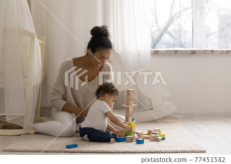 Loving African American mom play with little baby daughter Loving African American mom play with little baby daughter 77451582