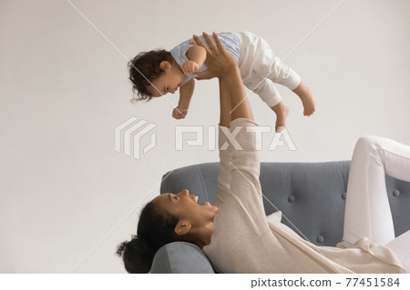 Happy African American mom play with toddler baby Happy African American mom play with toddler baby 77451584
