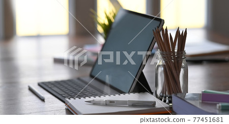 Office equipment on home working desk with tablet, pencil, pen and notebook. Office equipment on home working desk with tablet, pencil, pen and notebook. 77451681