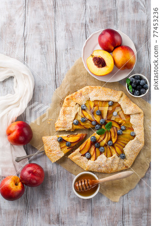 Homemade pie with peaches, ricotta and fresh blueberries 77453236